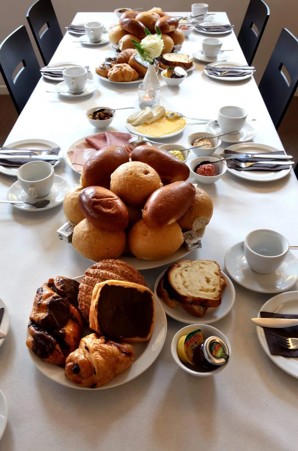 Koffietafel met broodjes, koffiekoppen en gebak