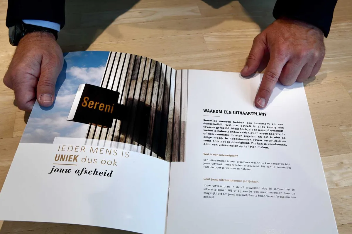 Een Sereni-uitvaartplanbrochure wordt samen overlopen aan tafel